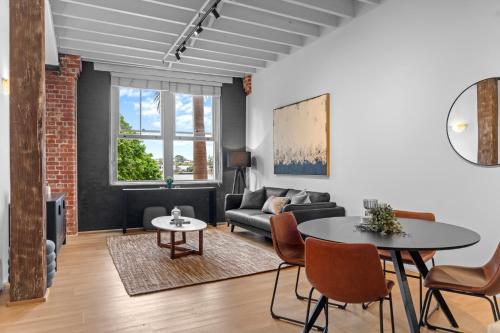 a living room with a couch and a table at Woolstore Riverfront Apartments Teneriffe in Brisbane