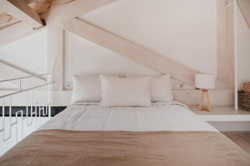 a white bedroom with a large bed with white pillows at Stella Maris in Pythagoreio