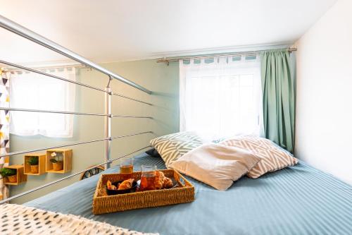 a bedroom with a bed with a tray of food on it at Le Nid Urbain - Stationnement dispo - à 2 pas de Paris in Arcueil