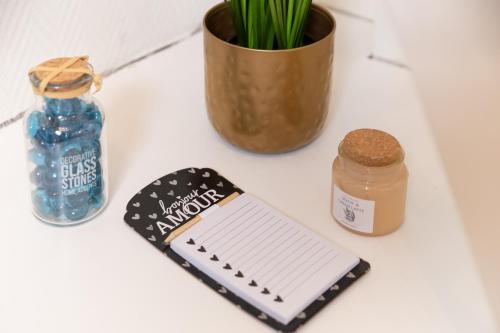 a table with a notebook and a bottle of water and a flowerpot at Le Nid Urbain - Stationnement dispo - à 2 pas de Paris in Arcueil