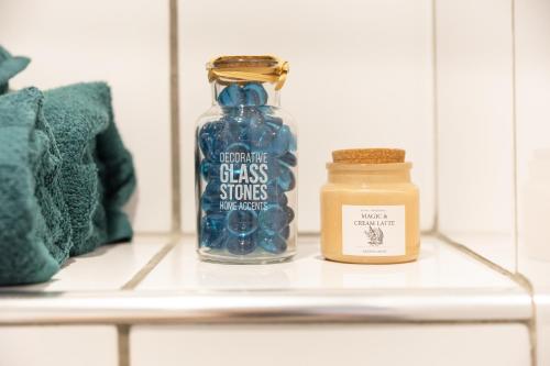 a glass bottle sitting on a shelf next to a candle at Le Nid Urbain - Stationnement dispo - à 2 pas de Paris in Arcueil