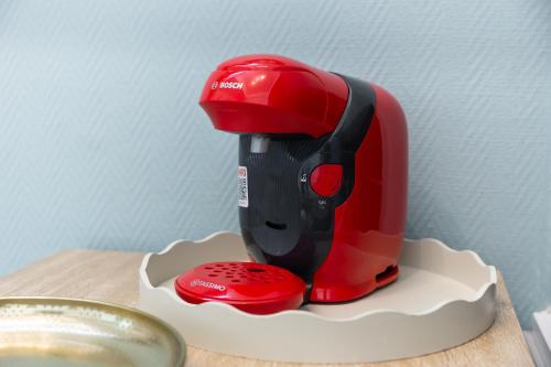 a red mixer sitting on a holder on a table at Le Nid Urbain - Stationnement dispo - à 2 pas de Paris in Arcueil
