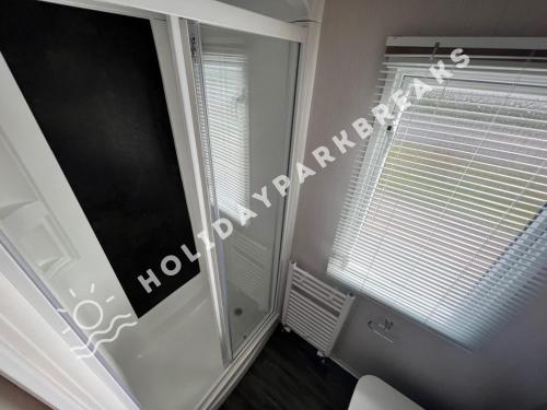 a room with a window with blinds and a mirror at Coopers Corner - Stylish 2 bedroom home, Seal Bay - Pets Welcome in Selsey