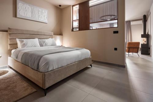 a bedroom with a large bed and a chair at Reve Suites Ioannina in Ioannina