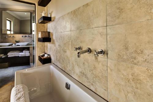 a bathroom with a bath tub with a sink at The Blades in Pretoria