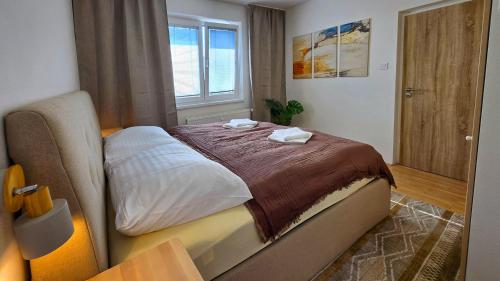 a bedroom with a bed with two towels on it at Urban Zen Stay in Banská Bystrica