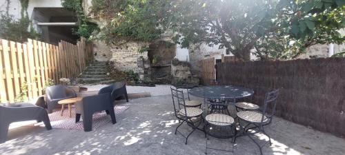 a patio with chairs and tables and a fence at Troglo entre Caves et Châteaux in Montlouis-sur-Loire