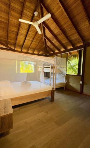 a bedroom with a large bed with a ceiling fan at Beach House la Tortuga, Punta Seca, Rincón del Mar 
