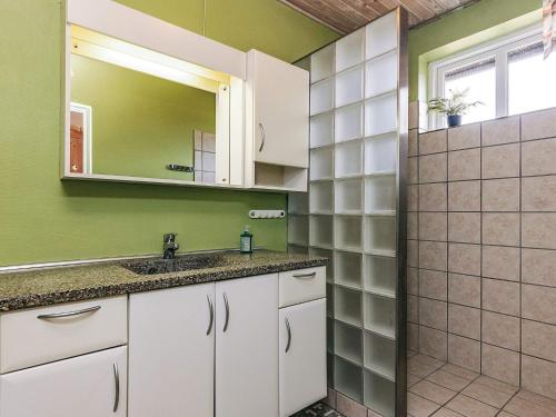 a bathroom with green walls and a sink and a mirror at 10 person holiday home in Spøttrup in Spottrup
