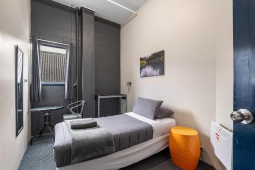 a bedroom with a bed and a table in it at Rock Solid Backpackers Rotorua in Rotorua