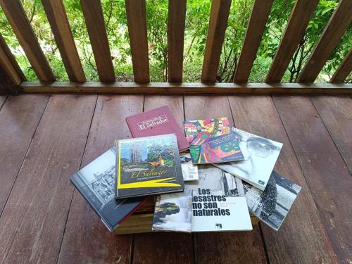 a pile of books sitting on a wooden deck at Cabaña Vista Pinares San Ignacio Chalatenango in Chalatenango