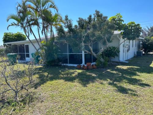 a house with palm trees in the yard at Duplex on CANAL all updated new furniture in Rotonda West