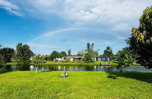 a rainbow over a lake with a boat in the grass at Duplex on CANAL all updated new furniture in Rotonda West