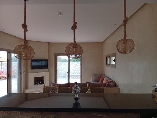 a living room with a couch and three hanging lights at Villa Khadija in Sidi Kaouki