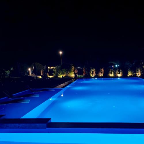a swimming pool at night with blue lights at Lula Apartments in Ulcinj