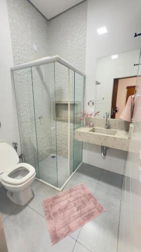 a bathroom with a shower and a toilet and a sink at Casa da Mih in Tangara da Serra