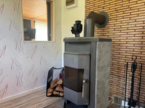 a wood fired stove in a room with a brick wall at Villa Bela in Högsby