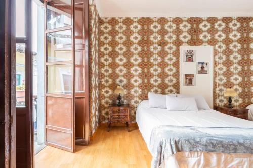 a bedroom with a bed and a wall covered in wallpaper at TRAVELER'S HOUSE QUITO in Quito