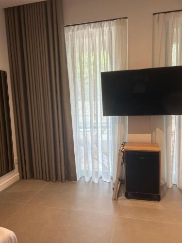 a bedroom with a flat screen tv in front of a window at Escape Suites in Dhërmi