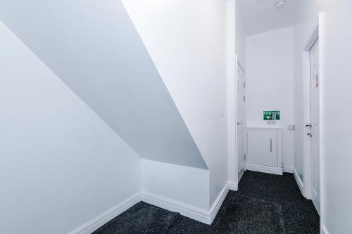 a hallway with white walls and a stair case at Four BR House By Eason Stays Short Lets & Serviced Accommodation Chorley With Free Parking in Chorley