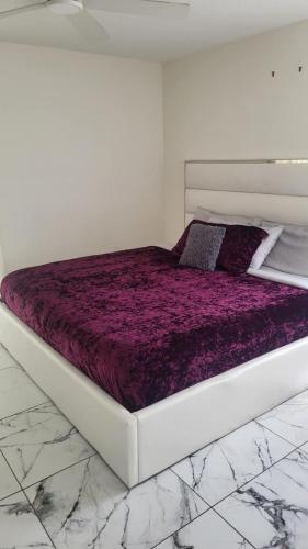 a bed in a white room with a purple mattress at Canal front new everything near Boca Grande Beach in Rotonda West