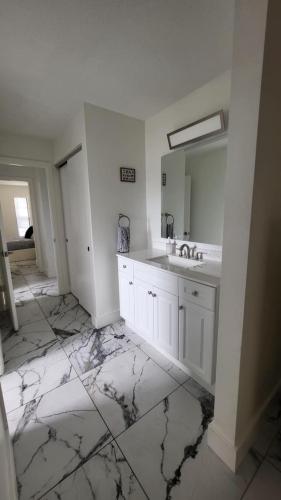 a white bathroom with a sink and a mirror at Canal front new everything near Boca Grande Beach in Rotonda West