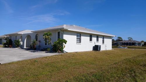 a white house with a large yard at Canal front new everything near Boca Grande Beach in Rotonda West