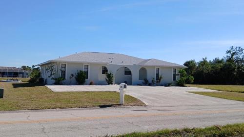 a white house with a driveway in front of it at Canal front new everything near Boca Grande Beach in Rotonda West