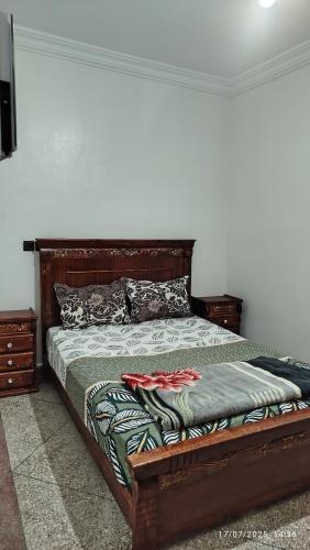a bedroom with a bed with a wooden frame at Peaceful family apartment in Agadir
