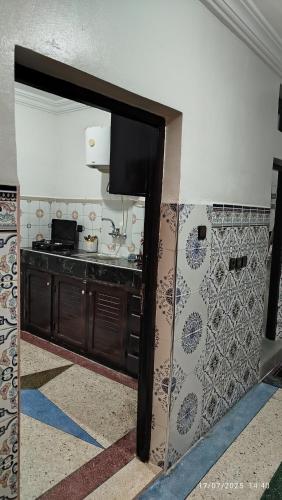 a kitchen with a sink and a tv on a wall at Peaceful family apartment in Agadir