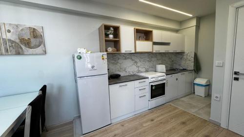 a kitchen with white cabinets and a refrigerator at The Urban Nest Central Skopje Cozy 2BR Ap in Skopje