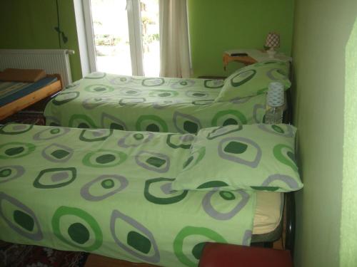 a bedroom with two beds with green and gray sheets at Agroturystyka SZYSZKA in Polnica