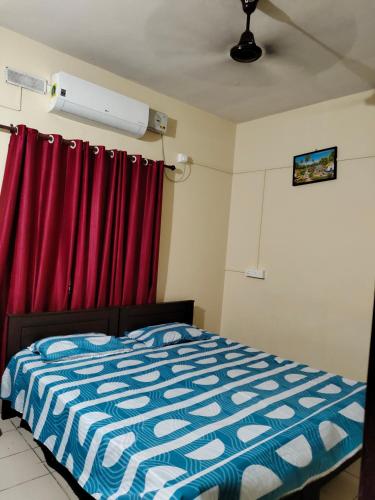 a bedroom with a bed and red curtains at MALABAR Residency in Perintalmanna
