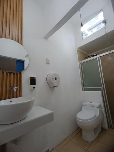 a white bathroom with a sink and a toilet at El Patio de Don Moncho in Nueva San Salvador
