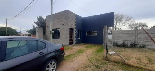a car parked in front of a blue house at La paz in Médanos