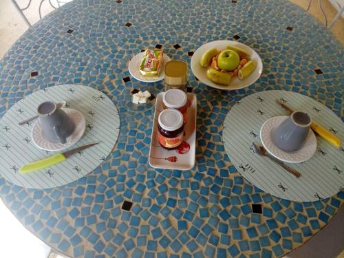 a table with plates and cups and utensils on it at Les Filaos-Villa entre fleuve saloum et ocean in Palmarin