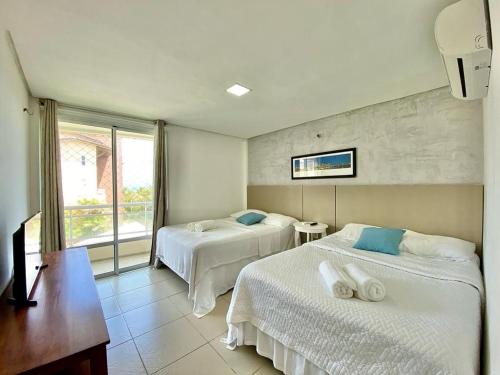 une chambre d'hôtel avec deux lits et une fenêtre dans l'établissement Sweet Home at the Beach - Next to Beach Park, à Aquiraz