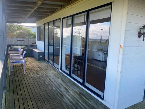 a screened porch with chairs and windows on a house at Waterfront Home with stunning views in Tarraville