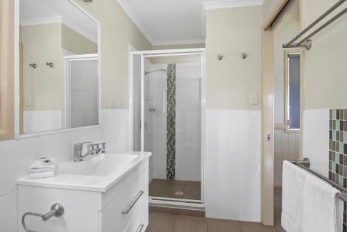 a white bathroom with a sink and a shower at Reflections Nambucca Heads - Holiday Park in Nambucca Heads