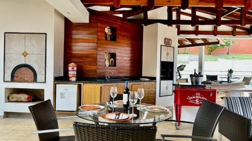 a kitchen with a glass table and chairs in a kitchen at Casa do Lago em Londrina in Londrina