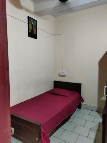 a bedroom with a red bed in a white wall at MALABAR Residency in Perintalmanna