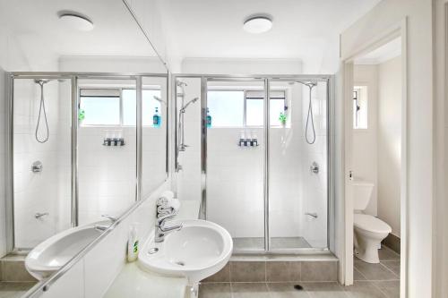 ein weißes Badezimmer mit Dusche und Waschbecken in der Unterkunft Oaks Family Getaway - Resort, Beach in Golden Beach