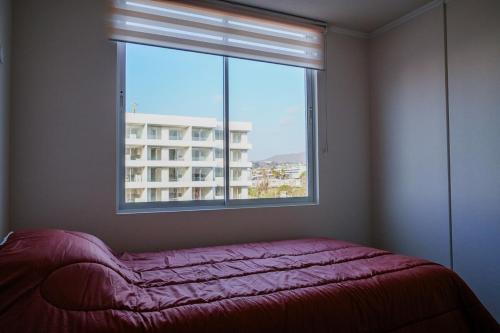 una camera da letto con una finestra e un letto rosa di fronte di Departamento 2H1B La Serena Condominio Distrito Verde a La Serena