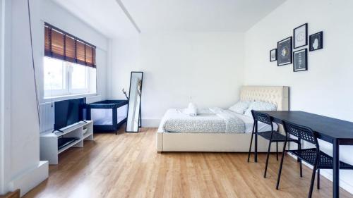 a bedroom with a bed and a table and chairs at Central London rooms EC1V in London