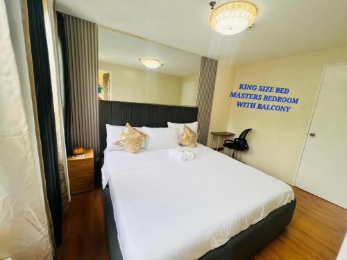 a bedroom with a white bed and a mirror at Cozy place at seawind condo, Davao City Near davao airport SMX Sm lanang Sasa wharf in Davao City