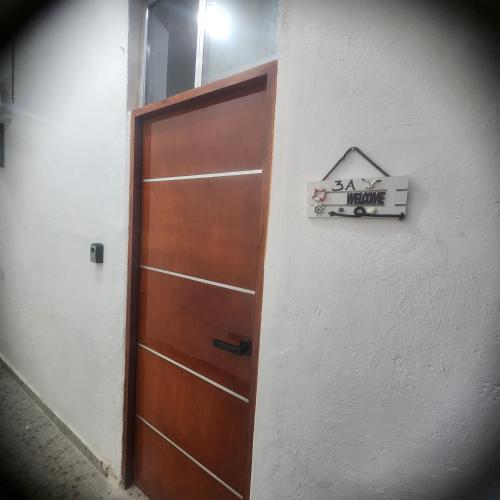a door in a room with a sign on a wall at Pequeño y acogedor espacio céntrico cerca de la playa, departamento 3A in Progreso