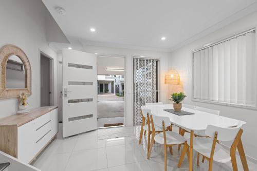 a kitchen and dining room with a white table and chairs at Carseldine Grove in Brisbane