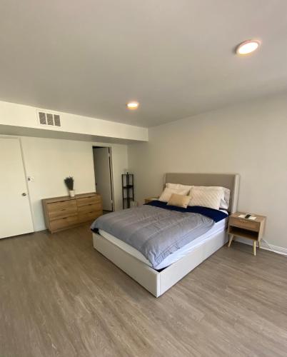 Un dormitorio con una cama grande y suelo de madera. en The Modern Nest, en Sherman Oaks