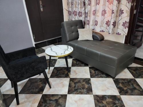 a black couch and a chair in a living room at Caesar's Hotel & Apartment Room 13 in Ikeja