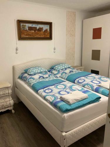 a bedroom with a large bed with blue and white sheets at Holiday Home Balatonbereny 2 in Balatonberény